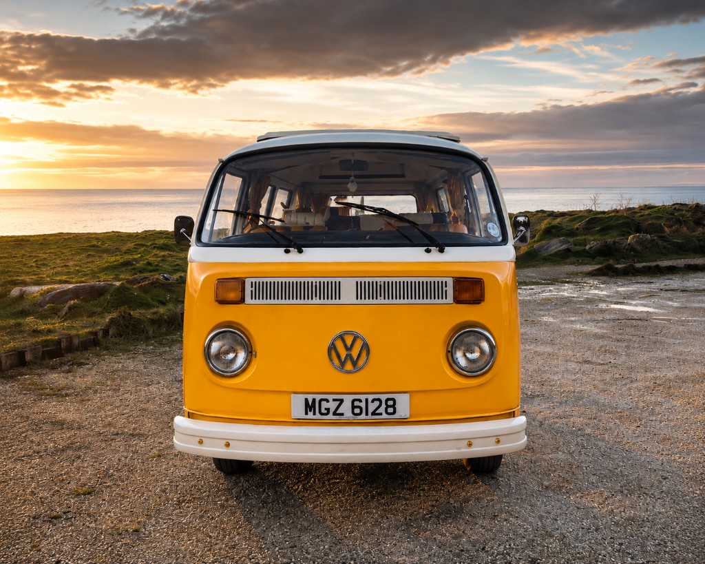 Vintage VW campervan at sunset by the coast
